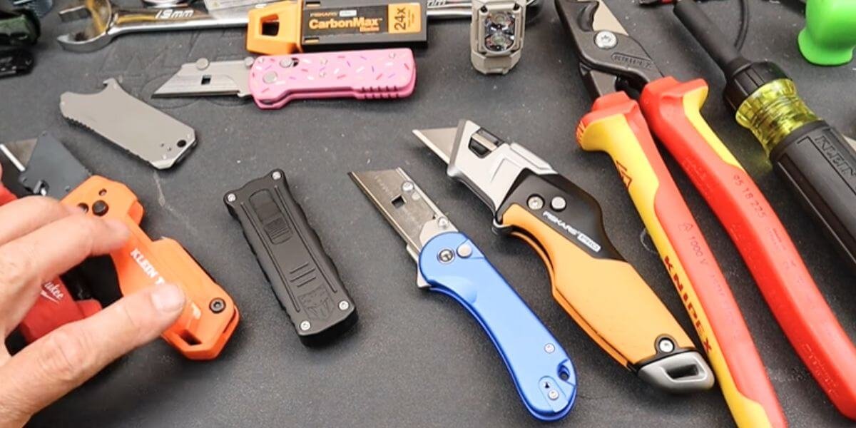 Assorted utility knives and tools on a work surface.