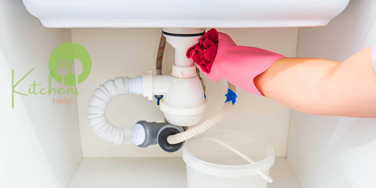 A person wearing pink rubber gloves is fixing a leak in the bathroom sink