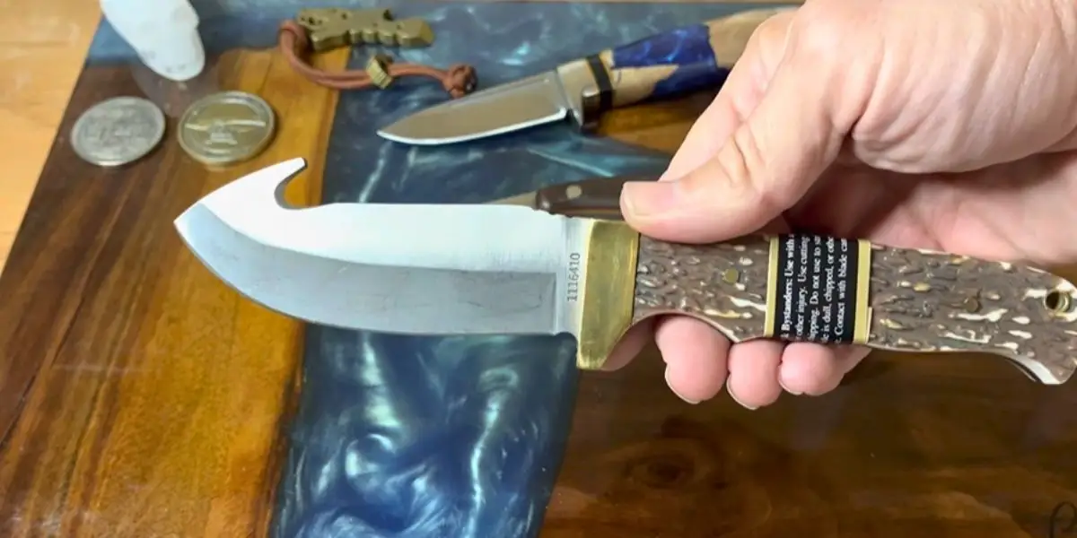 a man is holding a gut hook knife